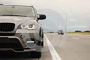 Grey modern car parked on asphalt road