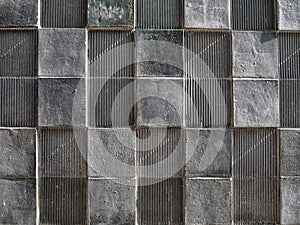 Grey concrete wall with geometric square pattern and distressed textures