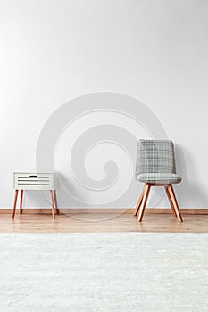 Grey chair near white nightstand