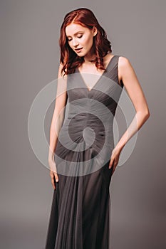 Grey chiffon long evening dress. Beautiful model in bridesmaid dress, modern feminine look for an event. Women`s fashion.
