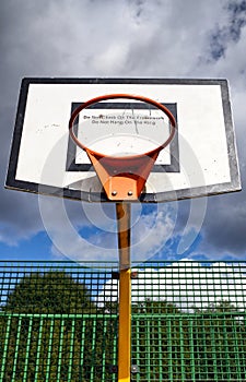 Sunlight on orange basketball hoop and board.