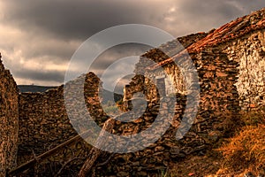 Grey clouds gather over the ruins of an abandoned Spanish cortijo. photo