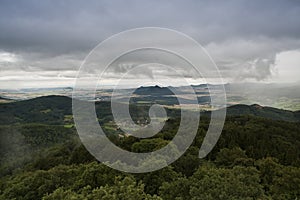 Grey clouds over green trees.