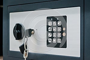 Grey compact safe with key and combination lock. Deposit module for storing money and documents at home and in the office