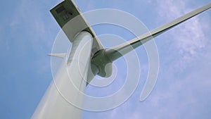 Grey contemporary windmill with large blades rotates