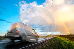 Grey delivery/cargo van going fast on a highway