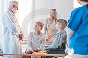 Grey doctor and female young intern working together at hospital