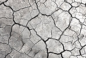 Grey dried and cracked ground earth background. Closeup of dry fissure dark ground. erosion