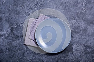 Grey empty plate and napkin on stone bakground place for text, copy space, top view