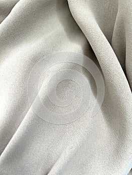 Grey fabric folds. Tissue folds. Smooth uniform grey fabric. Fabric abstract background. Gray texture. Monochrome