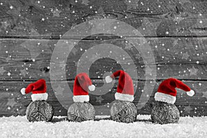 Grey festive wooden christmas background with four santa hats on