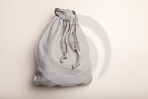 Grey fleece sack with tape on white background. Full tied container for small things, present concept. Top view, copy space.