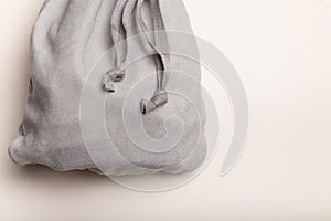 Grey fleece sack with tape on white background. Full tied container for small things, present concept. Top view, copy space.