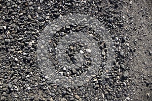 Grey gravel texture. Rustic road surface top view photo. Off-road ride or drive concept. Black gravel stone with sand