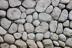 Grey or gray stone wall with natural texture round stone. Natural stone old style wall.