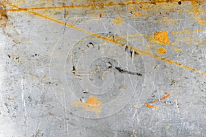 Grey grunge scratched metal sheet background. Worn steel surface texture with yellow paint