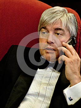 A grey-hair elderly imposing man in an interior