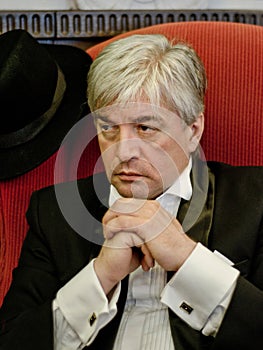 A grey-hair elderly mobster in an interior