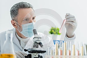 grey-haired bioengineer in medical mask