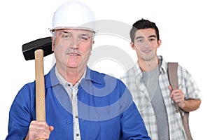 Grey-haired builder with apprentice