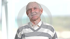 Grey haired man on blurred background.