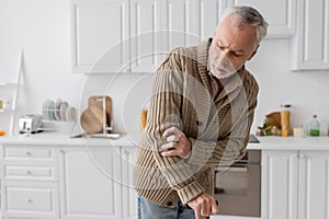 grey haired man suffering from parkinsonism