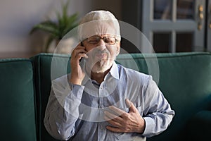 Grey haired man touching chest, having heart attack, calling emergency