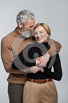 Grey haired man in turtleneck embracing