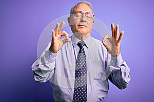 Grey haired senior business man wearing glasses standing over purple isolated background relax and smiling with eyes closed doing