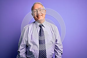 Grey haired senior business man wearing glasses standing over purple isolated background Relaxed with serious expression on face