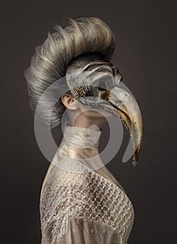 Grey haired woman in white dress and venetian mask