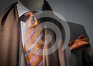 Grey jacket with brown scarf, orange tie and handk