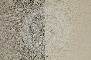 Grey and light-gray wall texture, background. Structural plaster, uneven surface. The corner of a wall or building