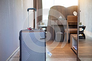 Grey Luggage in modern hotel room with windows, curtains and bed. Time to travel, relaxation, journey, trip and vacation concepts