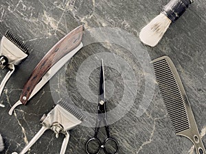 On a grey marble surface are old barber tools. top view. flat lay.