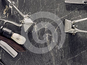 On a grey marble surface are old barber tools. top view. flat lay. copy space.