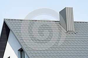 Grey metal profile roof installed on a modern house. Modern construction