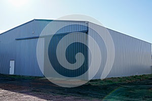 Grey metal warehouse wall closed gray gate and white door