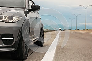 Grey modern car parked on asphalt road