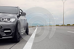 Grey modern car parked on asphalt road