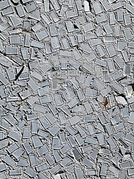 Grey Mosaic tiles on the wall of the house. Architectural abstract background texture. Gray concrete