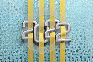 Grey numbers 2022 with golden ribbons on cyan background with stars. Happy new year concept.