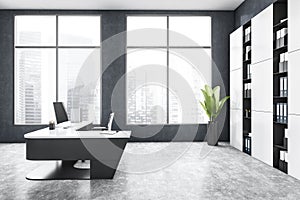 Grey office room with table and computer, window and shelf on marble floor