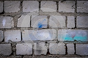 Grey, old brick stone wall texture background. Moody backdrop for design. Dark, weathered, aged, damaged blocks and stucco