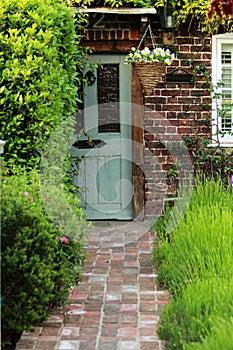Grey Old Door With Orange Bricky Wall and Green Lavender Garden