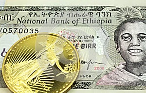 A grey one birr note from Ethiopia with a gold coin in macro