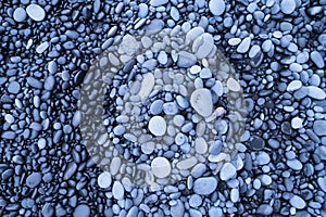 Grey pebbles as a background. Round stones on the beach. Photography for design.