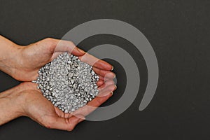 Grey pebbles for home decor and aquariums in hand