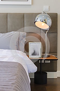 Grey pillow on bed with modern lamp
