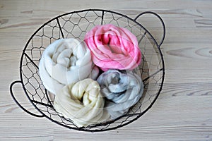 Grey, pink, vanilla and white merino wool in round wire basket